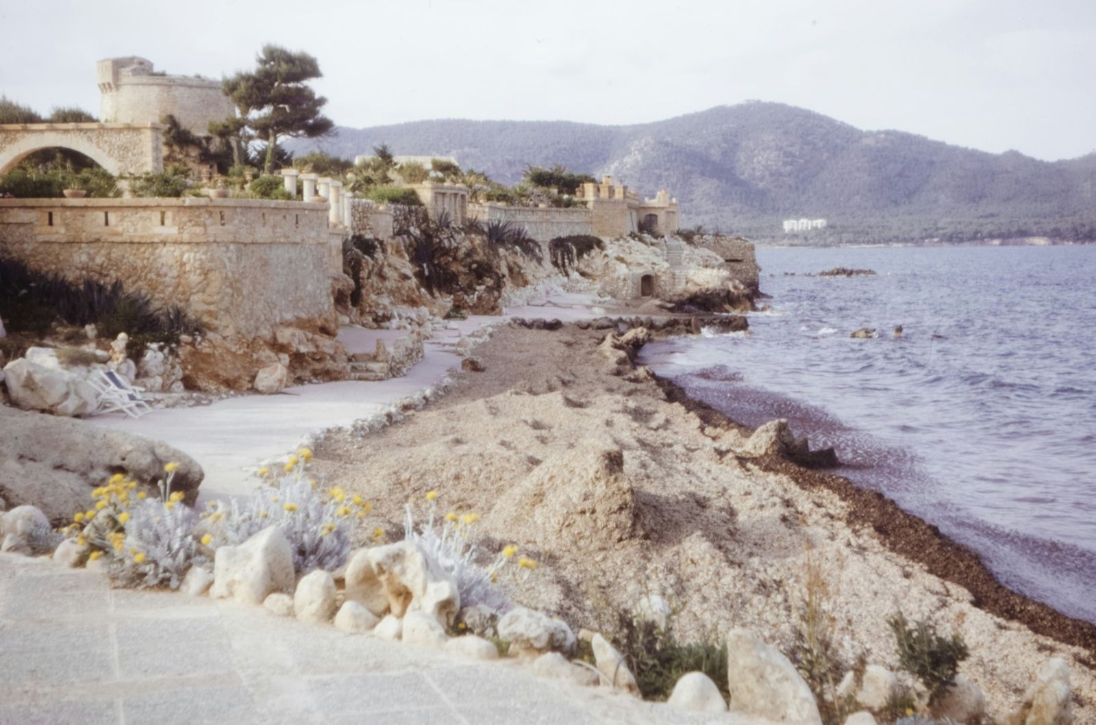Küstenweg am Meer mit Bergen im Hintergrund